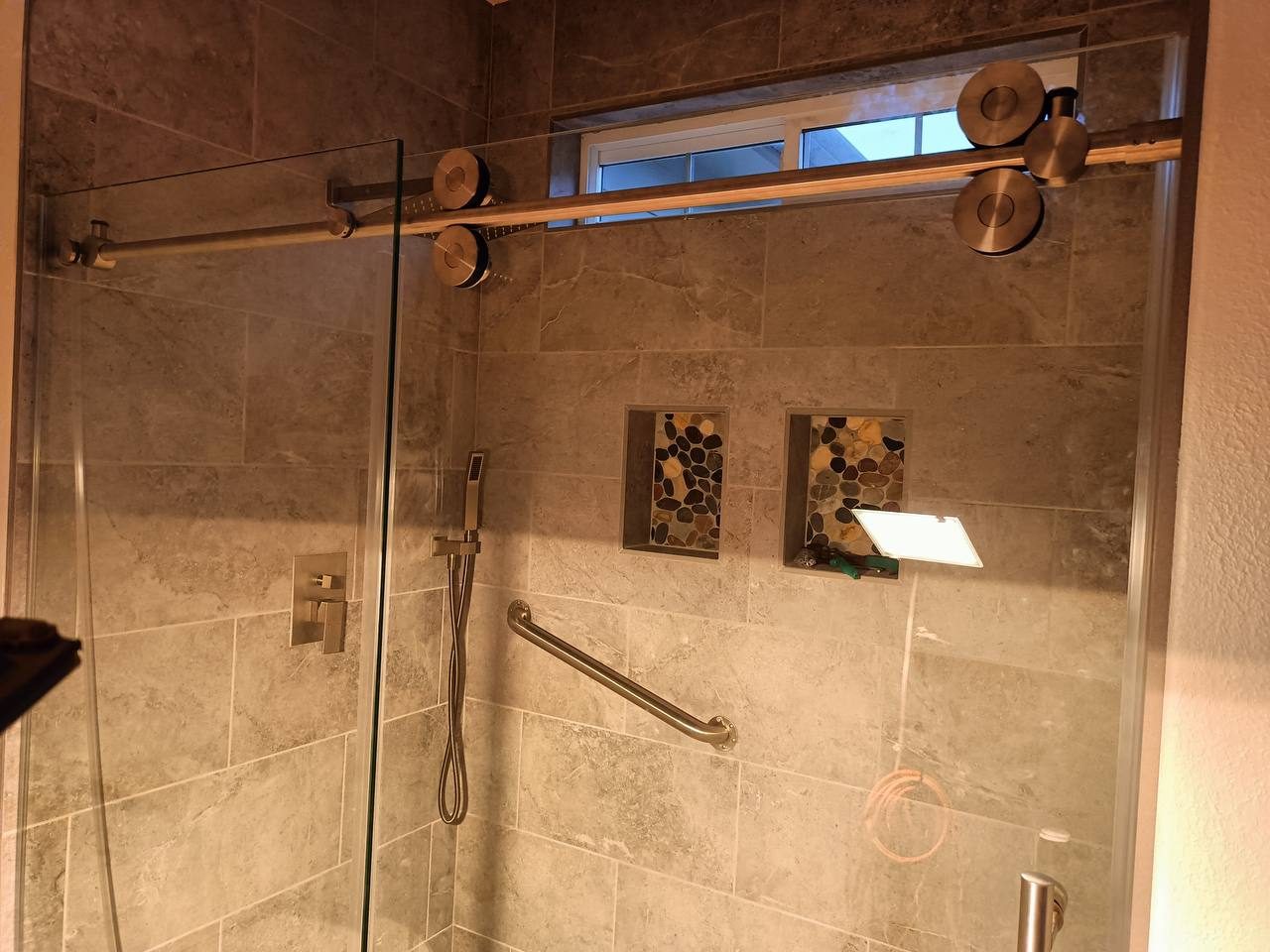 Finished tile shower with sliding glass door and accent shelf