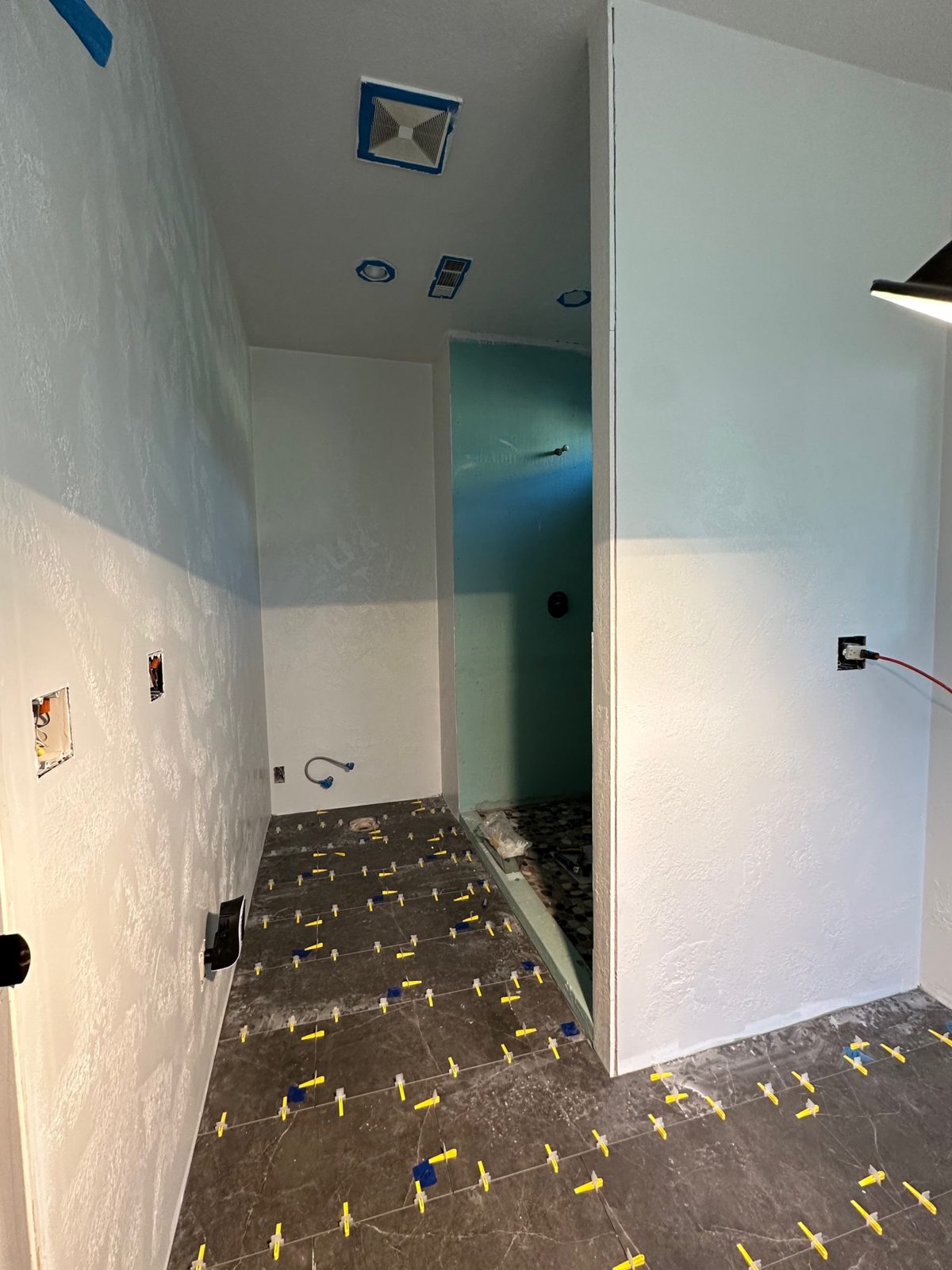 Bathroom floor tile being installed with spacers